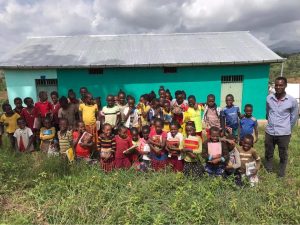 Ethiopian villagers holding new Open Hearts Big Dreams bilingual picture books outside their new library
